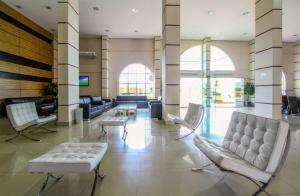 un vestíbulo con sofás y sillas en un edificio en Diroma Exclusive - Piscinas termais 24 horas, sauna, copa da mamãe, limpeza diária, estacionamento grátis!!!!, en Caldas Novas