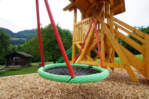 un parque infantil con un columpio y un tobogán en Schwendihaus, en Amden