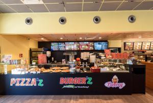 a pizza shop with a buffet of food at Hotel Cloppenburg in Cloppenburg +3 photos