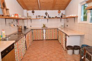 a kitchen with tile flooring and a long counter top at Pensiunea Morariu in Sălişte