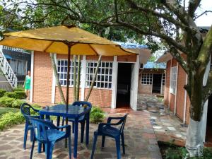 a blue table and chairs under an umbrella at Hotel Campestre Kosta Azul in Villavicencio