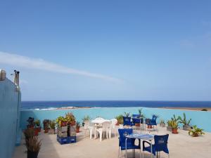 eine Terrasse mit Tischen und Stühlen und Meerblick in der Unterkunft Casa D'Mar in Ponta do Sol