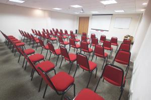 een kamer met rode stoelen in een klaslokaal bij Lummina Barueri Alphaville in Barueri