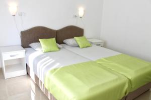 a bedroom with a large bed with green pillows at Apartments Villa Milna 1 in Budva