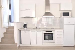 a white kitchen with a sink and a microwave at Apartments Villa Milna 1 in Budva