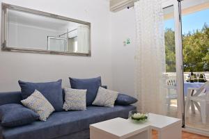 a living room with a blue couch and a mirror at Apartments Tila in Drasnice