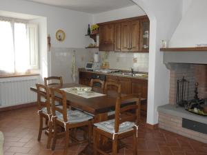 a kitchen with a table and chairs and a fireplace at Villa San marco in Cortona
