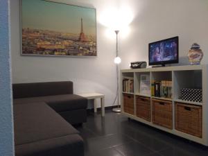 - un salon avec un canapé et une télévision dans l'établissement Apartamento Cantabrico, à Cadix