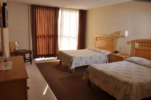 Postel nebo postele na pokoji v ubytování Hotel El Monte