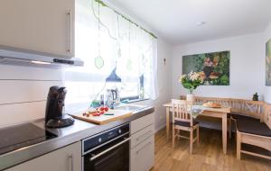 a kitchen with white cabinets and a sink and a table at Avalon Apartments in Rust