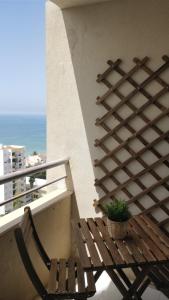 a wooden bench sitting on a balcony with a plant at Workspace.job in Portimão