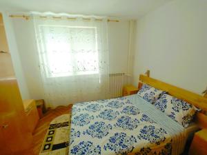 una camera con un letto blu e bianco e una finestra di Cazare apartament Constanta a Constanţa