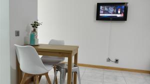 a table and chairs with a television on a wall at Workspace.job in Portimão
