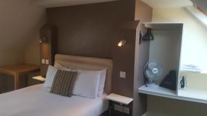 a small bedroom with a bed with white pillows at Beaumond Cross Inn in Newark upon Trent