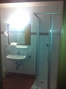 a bathroom with a sink and a shower with a mirror at Schnitzl-Eck in Flachau