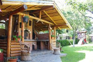 - un pavillon en bois avec deux chaises et une cheminée dans l'établissement Sura Pietrei Craiului, à Zărneşti