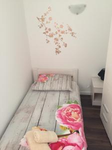a small bedroom with two beds and flowers on the wall at Magdalena Vacation House in Punat
