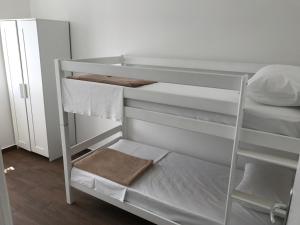 a white bunk bed with white sheets and towels at Apartments Kuk in Šilo +63 photos