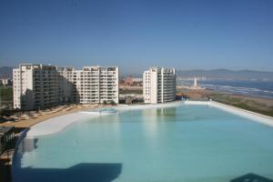 a large swimming pool in front of some buildings at Condominio Laguna del Mar in La Serena