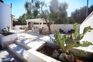 CerfignanoにあるIl Giardino Degli Aromiの木立のあるパティオ、テーブルと椅子