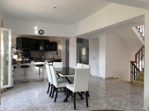 a kitchen and dining room with a table and white chairs at Virginia Beach Standalone Villa in El Alamein