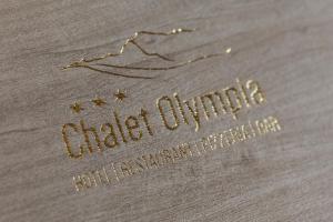 un logo per un negozio di abbigliamento su un tavolo di Hotel Chalet Olympia a Monguelfo