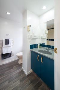 een badkamer met een blauwe wastafel en een toilet bij Annabelle Court Motel in Christchurch