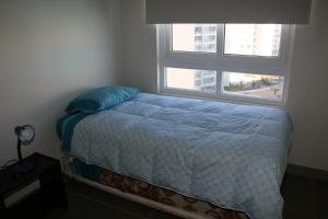 1 cama en un dormitorio con ventana en Condominio Laguna del Mar, en La Serena