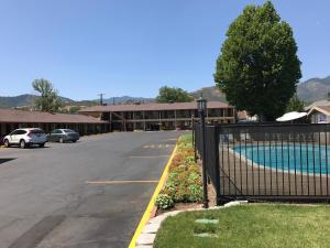 un aparcamiento con piscina frente a un edificio en Klamath Motor Lodge, en Yreka