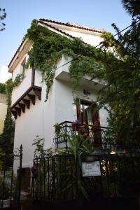 a white house with ivy on the side of it at Pension Felippe in Pythagoreio