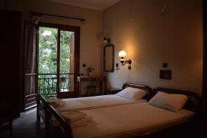 a bedroom with two beds and a large window at Pension Felippe in Pythagoreio