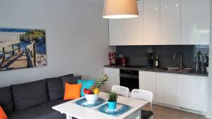 ウストロニエ・モルスキエにあるAPD Apartments - Rezydencja Ustronie Morskieのキッチン、リビングルーム(ソファ、テーブル付)