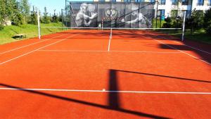 a tennis court with a net on a tennis court at APD Apartments - Rezydencja Ustronie Morskie in Ustronie Morskie