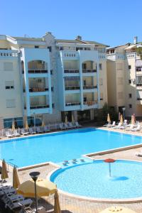 uma grande piscina com cadeiras e guarda-sóis em Golem Apartments em Golem