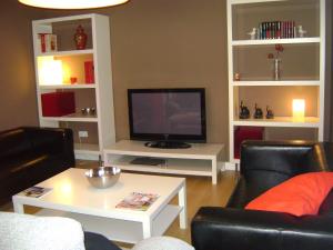a living room with a tv and a table and chairs at Casa La Rosa de los Vientos in Cobisa