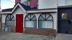 Casa blanca con puerta roja y ventanas en Isla de Lagos I en Ushuaia