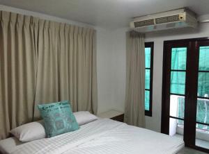 a bedroom with a bed with a pillow on it at Oriental Smile Hotel in Bangkok