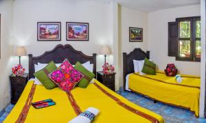 2 camas en una habitación con sábanas amarillas en Hotel Casa Rustica by AHS, en Antigua Guatemala