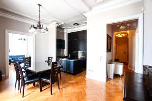 ein Esszimmer und eine Küche mit einem Tisch und Stühlen in der Unterkunft Art Deco Basilica Residence in Budapest