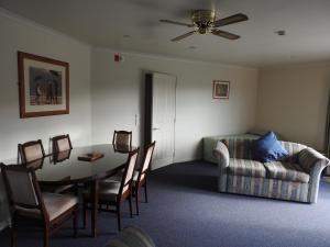 un soggiorno con un tavolo e un divano di A'Abode Motor Lodge a Palmerston North