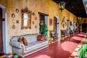 ein Wohnzimmer mit einem Sofa in der Mitte eines Zimmers in der Unterkunft Hotel Convento Santa Catalina by AHS in Antigua Guatemala