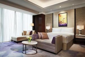 a hotel room with a bed and a couch at Fairmont Chengdu in Chengdu
