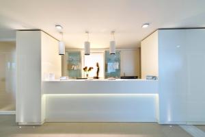 a white bathroom with a white sink and white cabinets at Parco Dei Principi Hotel Congress & SPA in Bari
