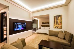 uma sala de estar com um sofá e uma cama em Kallirroe Hotel em Rio