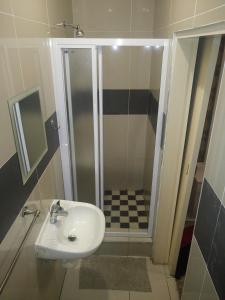 un baño con lavabo y ducha en The Union Hotel, en Durban