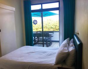 um quarto com uma cama e uma janela com uma mesa em Dumela Margate Flat No 4 em Margate
