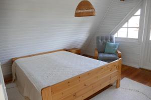 a bedroom with a bed and a blue chair at Tinore Holiday Home in Muratsi