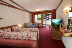 サースフェーにあるホテル イムセンのベッドとテレビが備わるホテルルームです。