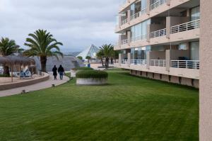 two people walking down a sidewalk next to a building at Sn Alfonso del Mar Edif.Goleta in Algarrobo