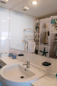 a white bathroom with a sink and a mirror at San Alfonso del Mar Edificio Goleta in Algarrobo